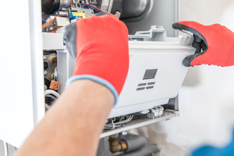 Gas engineer repairing a central heating boiler with tools